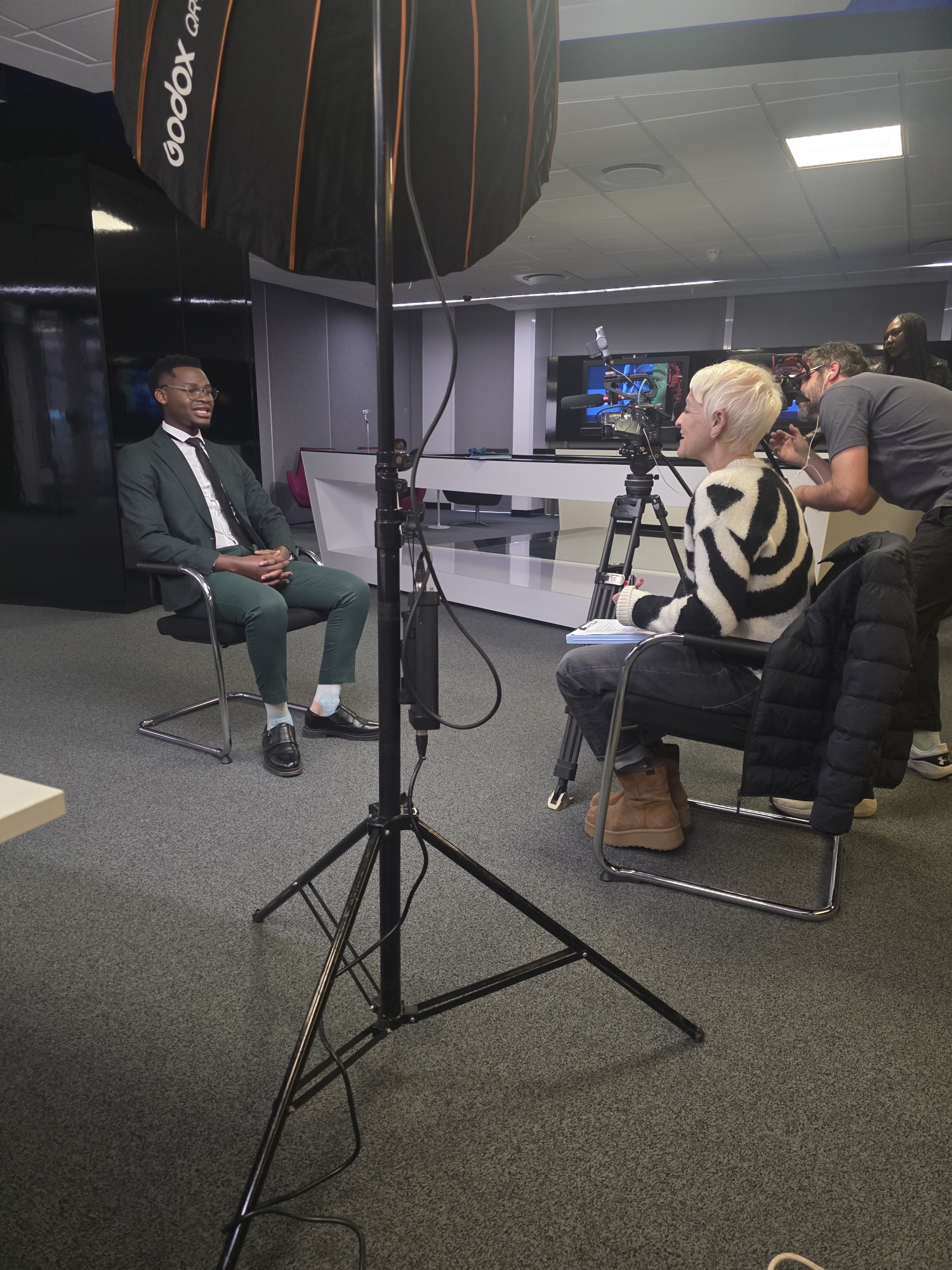 Shani facilitating an on-camera interview in an organisational setting
